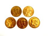 four different types of gold coins sitting on top of a white surface