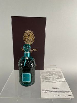 a bottle of perfume sitting on a table next to a box