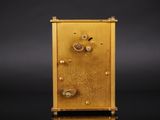 a gold clock that is sitting on a black surface