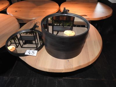 une table sur laquelle est posé un pot, posée elle-même sur une table en bois