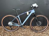 un vélo bleu appuyé contre un mur noir