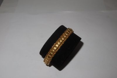 un gros plan d'une bague posée sur une surface blanche, avec un anneau en or