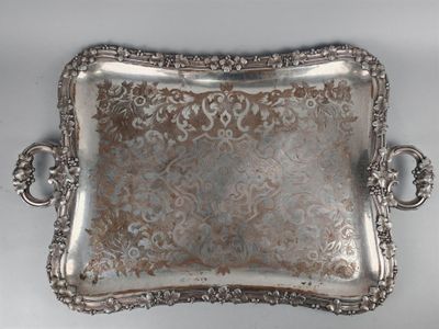 an ornate silver tray with handles on a white surface