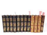 six vieux livres sont alignés sur une surface blanche