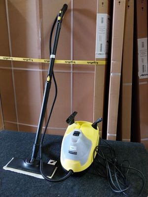 un nettoyeur à vapeur jaune et noir posé par terre à côté de cartons