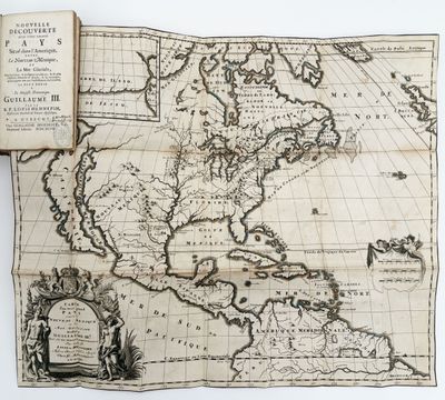 an old map of the americas with an open book on it
