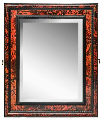un miroir à cadre rouge et noir sur fond blanc