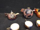 many different teapots and cups on the table