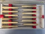 six knives in a box with red handles
