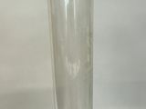 a clear glass vase with a black base on a table