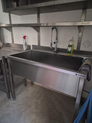 a stainless steel sink in the middle of a kitchen