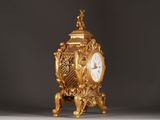 a gold clock sitting on top of a table