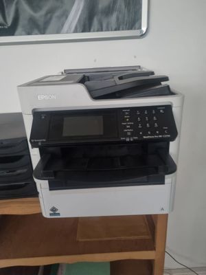 une imprimante posée sur une table en bois