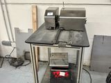 a picture of a kitchen area with a table and two ovens