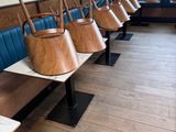 many wooden chairs lined up in a row in a restaurant