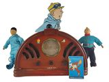 trois figurines représentant un homme et une femme posées sur une radio