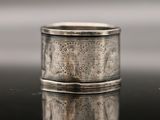 a close up of a silver ring sitting on top of a table