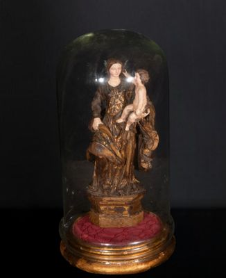 statue représentant une femme et un enfant, posée sur une table et recouverte d'un dôme en verre