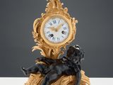 une petite horloge surmontée d'une statue