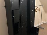 trois casiers noirs dans un coin d'une pièce