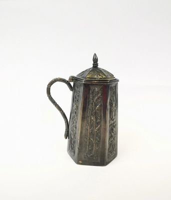 a silver coffee pot with a handle on a white surface