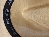 a white hat that has a black band around the brim