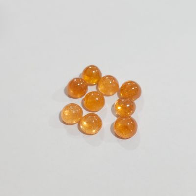 an image of a group of orange pills sitting on top of a white surface