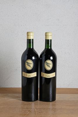 two bottles of wine sitting on top of a wooden table