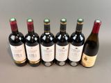 six bottles of wine lined up in a row on a table