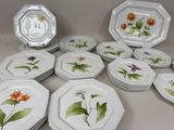 de nombreuses assiettes ornées de fleurs, posées sur une table