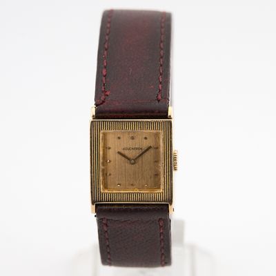 une photo d'une montre-bracelet plaquée or avec un bracelet en cuir marron