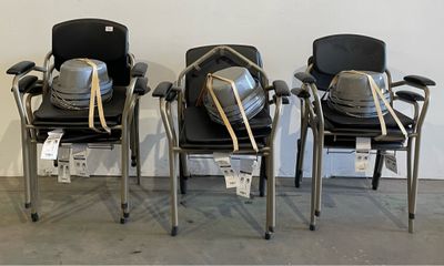 three chairs with backpacks sitting on them in a room