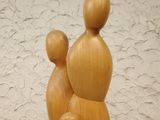 a wooden sculpture of a mother and two children