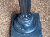a metal pole with a black base on the carpet