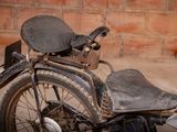 a old motorcycle that is parked in front of a brick wall