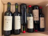 several bottles of wine in a cardboard box on a table