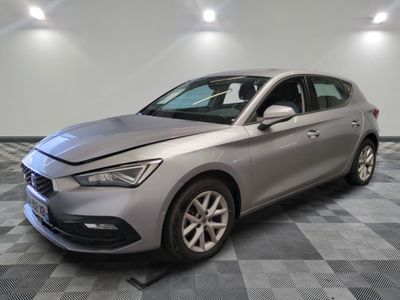 une voiture argentée est garée dans une pièce au sol en damier