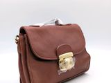 the small brown purse is sitting on top of a white surface