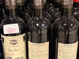 several bottles of wine are lined up on a shelf in a store