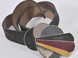 black leather belt with silver, red, and yellow metal buckle