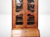 un secrétaire ancien en bois, doté de portes vitrées et de tiroirs