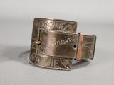 a close up of a metal belt buckle with writing on it