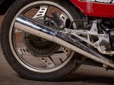 a close up of a red motorcycle parked in a garage