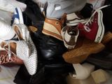 a pile of shoes and shoes that are on top of a bed