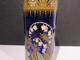 un vase bleu orné de motifs dorés, posé sur une table