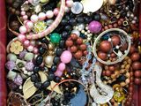 une boîte rouge remplie d'un assortiment de perles et de bijoux