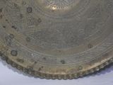 a silver plate with a design on it sitting on a table