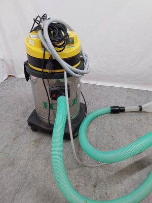 a vacuum that is sitting on the floor next to a hose