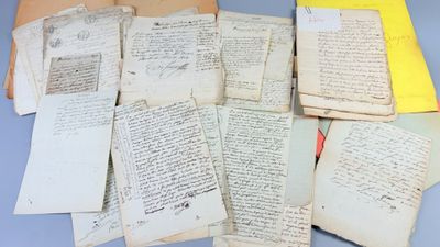 a pile of old papers sitting on top of a blue table