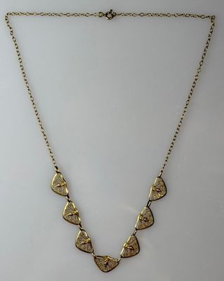 a gold necklace with five triangulars on a chain